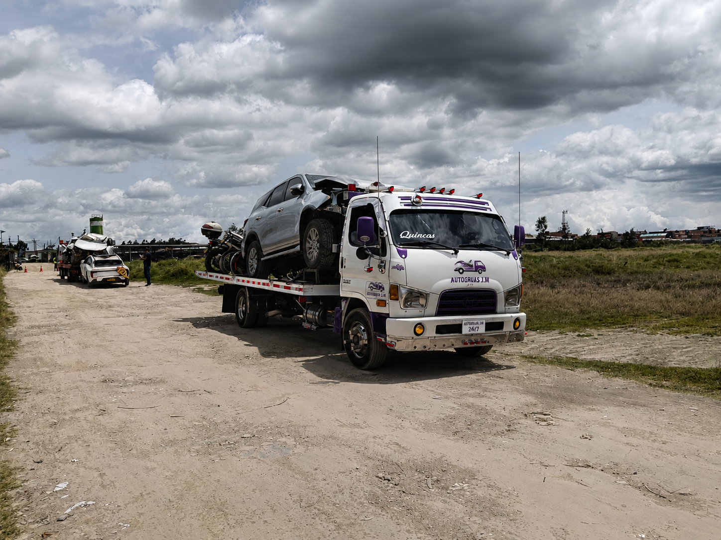 Grúa de Autogrúas J.M transportando vehículo accidentado
